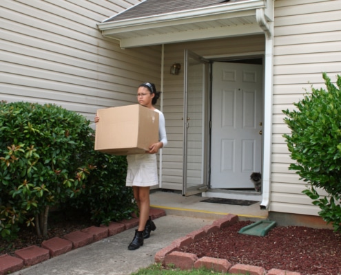JBAY a young woman holding a cardboard box